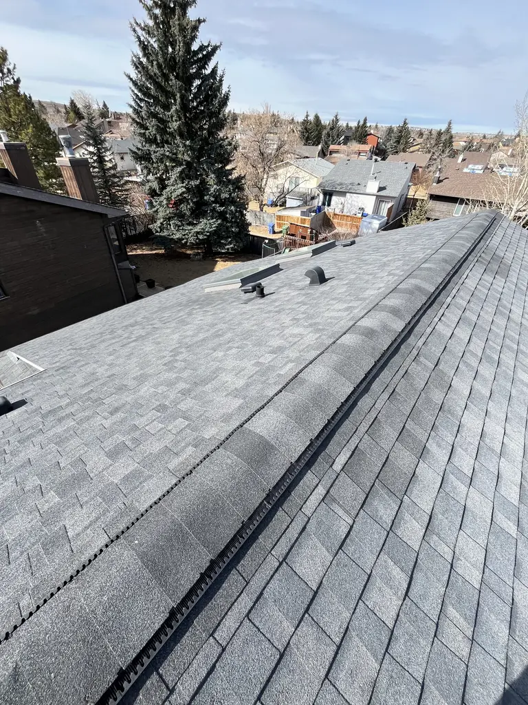 Completed asphalt shingle roof with new ridge vents on a Calgary home, 2025