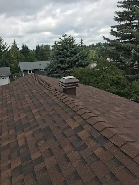 Redwood IKO shingle roof with high-profile ridge caps on a Calgary home