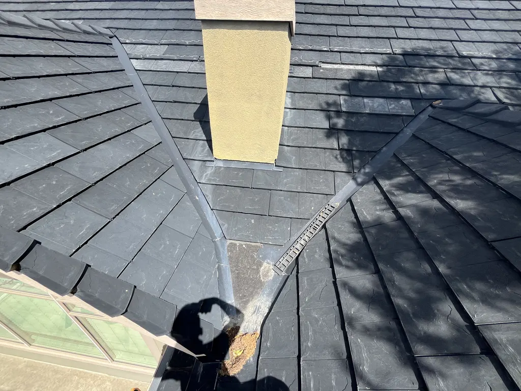 Chimney base flashing and metal valley flashing on a synthetic slate roof repaired in Calgary